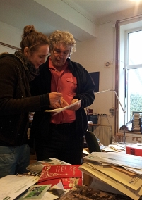 Heinrich Staudinger steht in seinem Büro, vor ihm auf dem Schreibtisch, Bücher, Zeitschriften und Flugblätter.